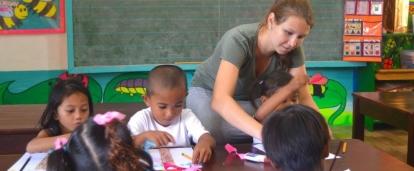A Childcare volunteer helps a group of young children with a colouring excercises in the Philippines. A Projects Abroad volunteer working with children in the Philippines teaches colouring exercises.